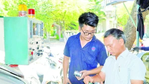 Ông Lê Thêm (bên phải) cùng cộng sự nghiên cứu sáng chế sản phẩm mới.