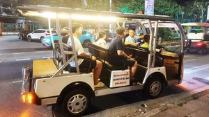 Xe điện chở khách du lịch tham quan thành phố Đồng Hới về đêm.