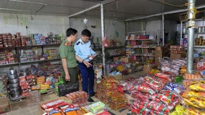 Lực lượng chức năng phối hợp kiểm tra hàng hóa là thực phẩm, sữa, thuốc tại các quầy hàng trung tâm thành phố Điện Biên Phủ. 