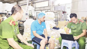 Lực lượng Công an tỉnh Hưng Yên kiểm tra, làm việc với Công ty TNHH Sản xuất và Xuất nhập khẩu Nhật Minh Food. (Ảnh TTXVN)
