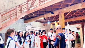 1. Các thanh niên kiều bào tham quan nhà dài truyền thống của dân tộc Ê Đê tại Bảo tàng Thế giới cà-phê.