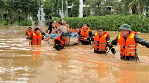 Cán bộ, chiến sĩ Công an tỉnh Nghệ An sơ tán người dân ra khỏi vùng nguy hiểm.