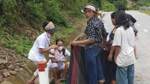 Hai cán bộ Trạm Y tế xã Mường Típ đỡ đẻ cho sản phụ trên đường. (Ảnh: NGỌC MAI)