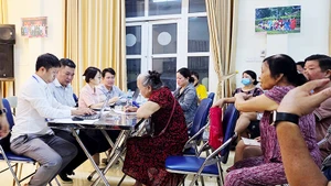 Người dân nhận tiền quà tại UBND phường. Ảnh: NAM NGUYỄN