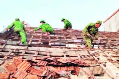 Cán bộ, chiến sĩ Bộ đội Biên phòng tỉnh giúp dân tháo dỡ nhà cũ, dột nát.