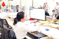 Người dân làm thủ tục hành chính tại Ủy ban nhân dân quận Bình Tân trước thời điểm thực hiện mô hình chính quyền địa phương hai cấp. (Ảnh THẾ ANH)