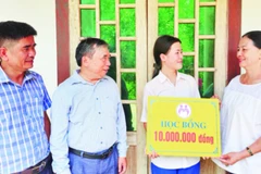 Cô Thái Thị Lan trao học bổng tặng em Tạ Trần Thị Nhi trước sự chứng kiến của lãnh đạo Phòng Giáo dục và Đào tạo huyện Gio Linh và Hiệu trưởng nhà trường.