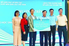 Đại diện Nhà xuất bản Giáo dục Việt Nam trao tặng sách giáo khoa cho học sinh vùng lũ Quảng Ngãi. (Ảnh ÁI KIỀU)