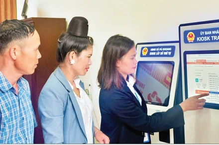 Công chức xã Mường Phăng, tỉnh Điện Biên hướng dẫn nhân dân cách giải quyết thủ tục hành chính trên cây tại Trung tâm dịch vụ hành chính công tại xã.