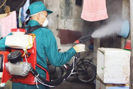Cán bộ y tế phun hóa chất phòng chống bệnh sốt xuất huyết tại các hộ gia đình ở Hà Nội.
