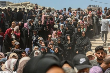 Người dân Palestine chờ được phát thực phẩm cứu trợ tại Gaza. (Ảnh: THX/TTXVN)