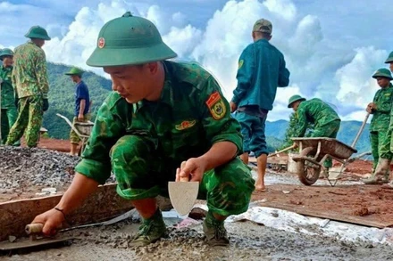 Chiến sĩ Ban Chỉ huy Bộ đội Biên phòng tỉnh Điện Biên giúp người dân bản Háng Pù Xi, xã Xa Dung làm nhà ở mới sau lũ quét