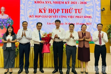 Lãnh đạo tỉnh Lào Cai tặng hoa chúc mừng tân Chủ tịch Hội đồng nhân dân tỉnh Trịnh Việt Hùng. (Ảnh: THANH SƠN)