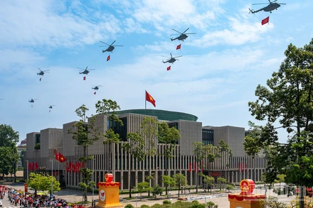 Biên đội 10 chiếc trực thăng kéo cờ Đảng, cờ Tổ quốc bay qua quảng trường Ba Đình. (Tác giả: GIANG HUY)