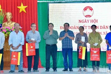 Thủ tướng Phạm Minh Chính tặng quà các hộ dân ở khu dân cư Thắng Kiên, xã Đề Gi, nhân Ngày hội Đại đoàn kết toàn dân tộc. (Ảnh: THANH GIANG)