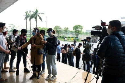 Các phóng viên tác nghiệp tại Bệnh viện Nhiệt đới trung ương. (Ảnh: DUY LINH)