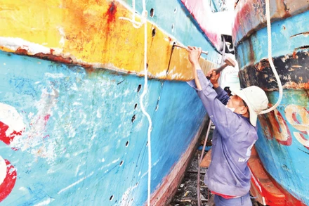 Ngư dân xã Đề Gi (tỉnh Gia Lai) đang tập trung sửa chữa tàu cá bị hư hỏng do bão số 13 để có thể sớm vươn khơi.