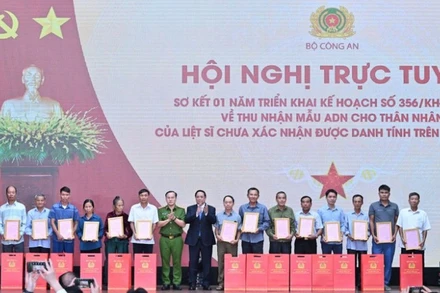 Thủ tướng Chính phủ Phạm Minh Chính trao Thông báo kết quả giám định ADN hài cốt liệt sĩ cho đại diện thân nhân các gia đình liệt sĩ. (Ảnh: TRẦN HẢI) 