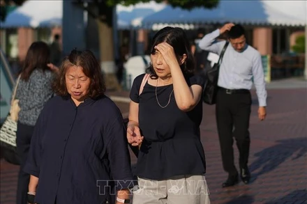 Người dân di chuyển trên đường phố dưới trời nắng nóng tại Tokyo, Nhật Bản. (Ảnh: THX/TTXVN)