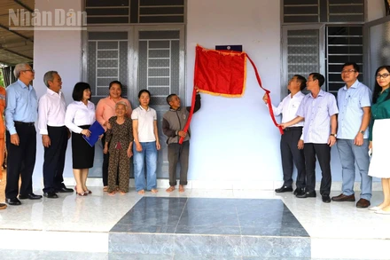 Các đại biểu và gia đình anh Nguyễn Hữu Dũng thực hiện nghi thức kéo băng khánh thành ngôi nhà.