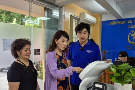 Người dân trải nghiệm Robot AI hỗ trợ thực hiện các thủ tục hành chính tại phường Cửa Nam, thành phố Hà Nội. (Ảnh NGUYỄN THẮNG)