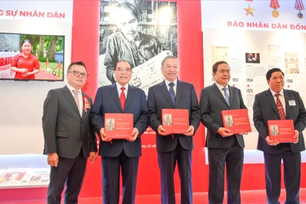 Tổng Bí thư Tô Lâm, các đồng chí lãnh đạo Đảng, Nhà nước và các đại biểu nhận cuốn sách " Những bài viết về văn hóa, báo chí của Bác Hồ trên Báo Nhân Dân" tại gian trưng bày của Báo Nhân Dân. 