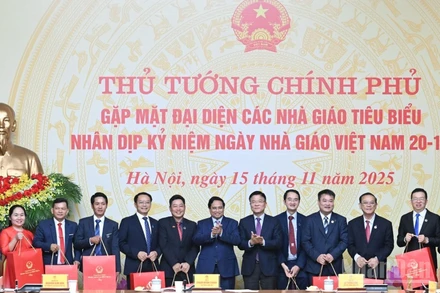 Thủ tướng Chính phủ Phạm Minh Chính tặng quà chúc mừng các giáo viên tiêu biểu tại buổi gặp mặt. (Ảnh: TRẦN HẢI)