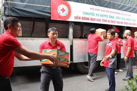Cán bộ Hội Chữ thập đỏ Thành phố Hồ Chí Minh bốc xếp lương thực và nhu yếu phẩm lên xe ủng hộ đồng bào bị thiên tai, bão lũ tại thành phố Huế. 