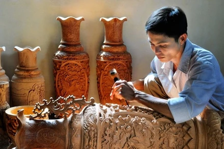 Người thợ chạm khắc gỗ tại làng nghề truyền thống Vân Hà (Hà Nội).