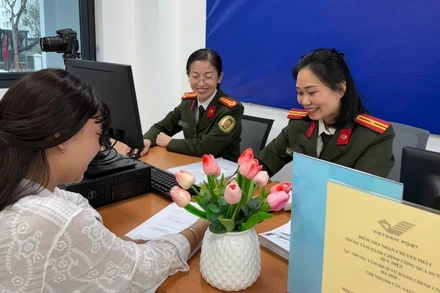 Cán bộ Công an thành phố Hà Nội hướng dẫn người dân kê khai làm thủ tục cấp hộ chiếu.