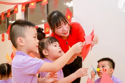 Cô và trò cùng nhau làm lá cờ đỏ sao vàng.