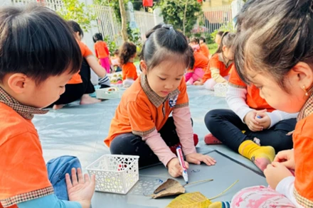Các bạn nhỏ trong giờ hoạt động tạo hình con vật từ lá cây tại Trường mầm non Tuổi thơ (quận Hoàng Mai). 