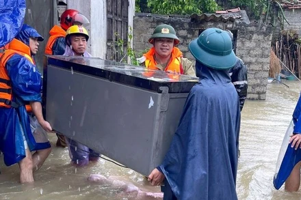 Lực lượng chức năng di dời tài sản của người dân ra khỏi vùng ngập nước.