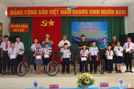 Đại diện Đồn Biên phòng Xuân Hòa phối hợp với Ủy ban Mặt trận Tổ quốc Việt Nam xã Xuân Cảnh trao quà cho các em học sinh.