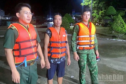 Cán bộ, chiến sĩ Đồn Biên phòng Khánh Hội cứu vớt ngư dân gặp nạn (giữa) đưa vào bờ an toàn.