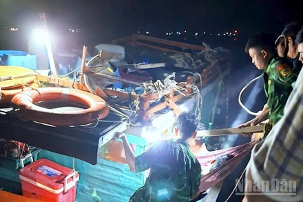 Cán bộ, chiến sĩ Đồn Biên phòng Hòn Chuối hỗ trợ đưa ông Đạt xuống tàu vào bờ tiếp tục cấp cứu, điều trị.