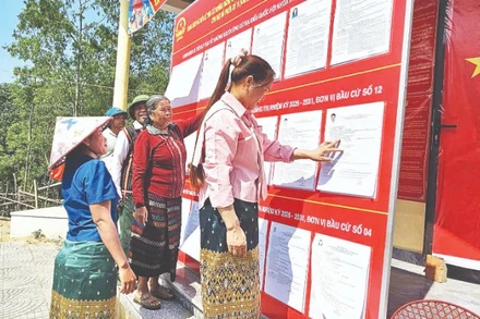 Đồng bào dân tộc thiểu số ở phía bắc tỉnh Quảng Trị đọc thông tin các ứng cử viên. (Ảnh: HƯƠNG GIANG)