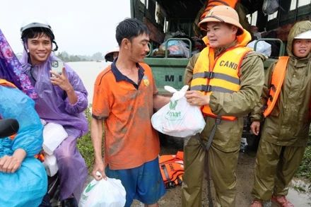 Trao quà cứu trợ đến với người dân vùng lũ tỉnh Đắk Lắk. (Ảnh TTXVN)