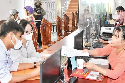 Cán bộ Trung tâm Phục vụ hành chính công phường Mỹ Phong hướng dẫn người dân đến làm thủ tục hành chính. 