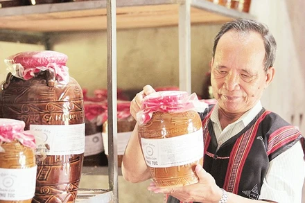 Ông Lê Văn Nghĩa kiểm tra chất lượng sản phẩm rượu cần. 