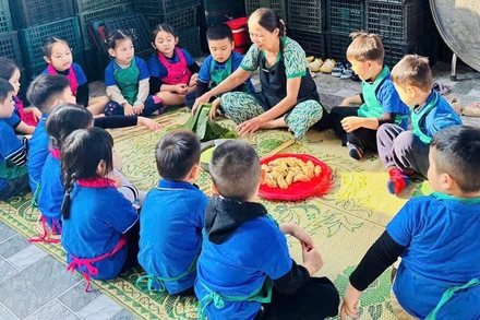 Học sinh đến trải nghiệm gói bánh tét mặt trăng ở làng Đại An Khê. (Ảnh: QUANG HUY)