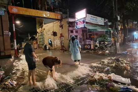 Người dân phường Trảng Dài, tỉnh Đồng Nai, khơi thông dòng chảy sau mưa lớn.