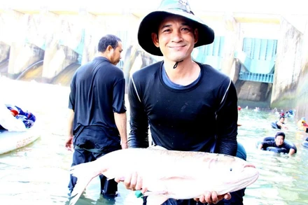 Niềm vui của một người dân khi bắt được cá tại khu vực chân đập Thủy điện Trị An.