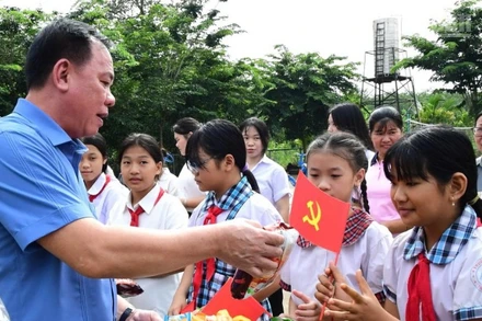 Đồng chí Võ Tấn Đức, Phó Bí thư Tỉnh ủy, Bí thư Đảng ủy, Chủ tịch Ủy ban nhân tỉnh Đồng Nai cùng với trẻ em và người dân khu vực biên giới xã Thanh Hòa.
