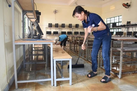 Giáo viên Trường trung học cơ sở Phước Tân 1 dọn dẹp phòng học sau lũ.