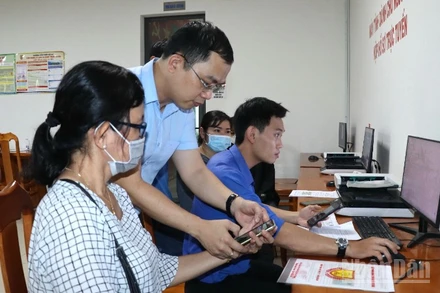 Lãnh đạo xã Long Thành hướng dẫn người dân nộp hồ sơ trực tuyến tại Trung tâm Phục vụ hành chính công.