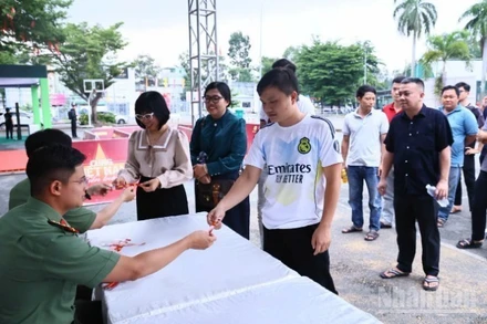 Các bạn trẻ đến nhận vòng đeo tay của hoạt động đi bộ "Cùng Việt Nam tiến bước" vào chiều 15/8 tại Trung tâm Huấn luyện và Thi đấu thể dục thể thao Đồng Nai.