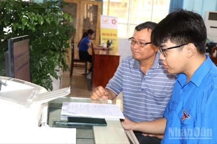 Ông Nguyễn Minh Trí được tình nguyện viên Tỉnh đoàn Đồng Nai hỗ trợ nộp hồ sơ trực tuyến.