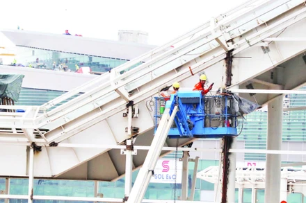 Lắp đặt thiết bị bên ngoài nhà ga hành khách sân bay Long Thành. (Ảnh THIÊN VƯƠNG)