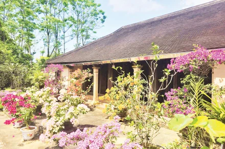 Một ngôi nhà rường cổ trong khuôn viên vườn ngập sắc hoa ở Hội Kỳ.